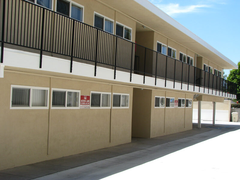 Aparicio Apartments V. - Orange Avenue complex sits against a sunny sky, with a clean exterior.