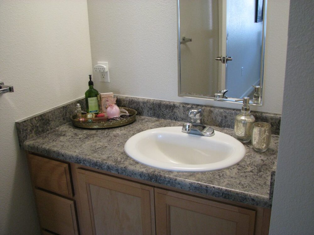 A bathroom vanity, sink, and mirror.