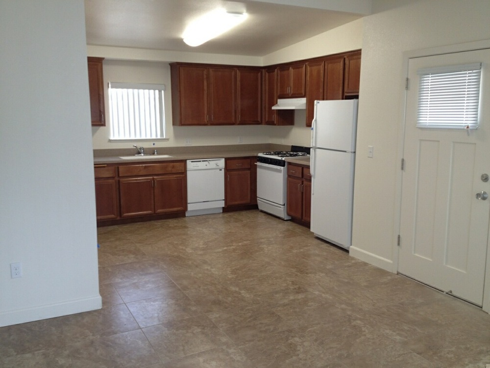 A clean, empty kitchen is to the left of the front door. 