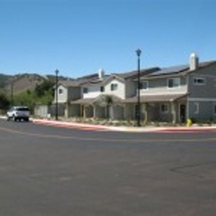 Creekside Village apartments sit just off the highway, against a sunny sky. 